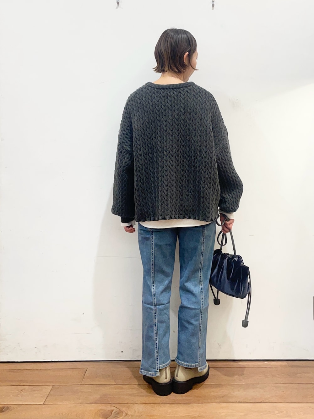 グレー系のニット/セーター、ホワイト系のTシャツ/カットソー、ブルー系のショルダーバッグを着用したレディースの冬コーディネートの5枚目の写真