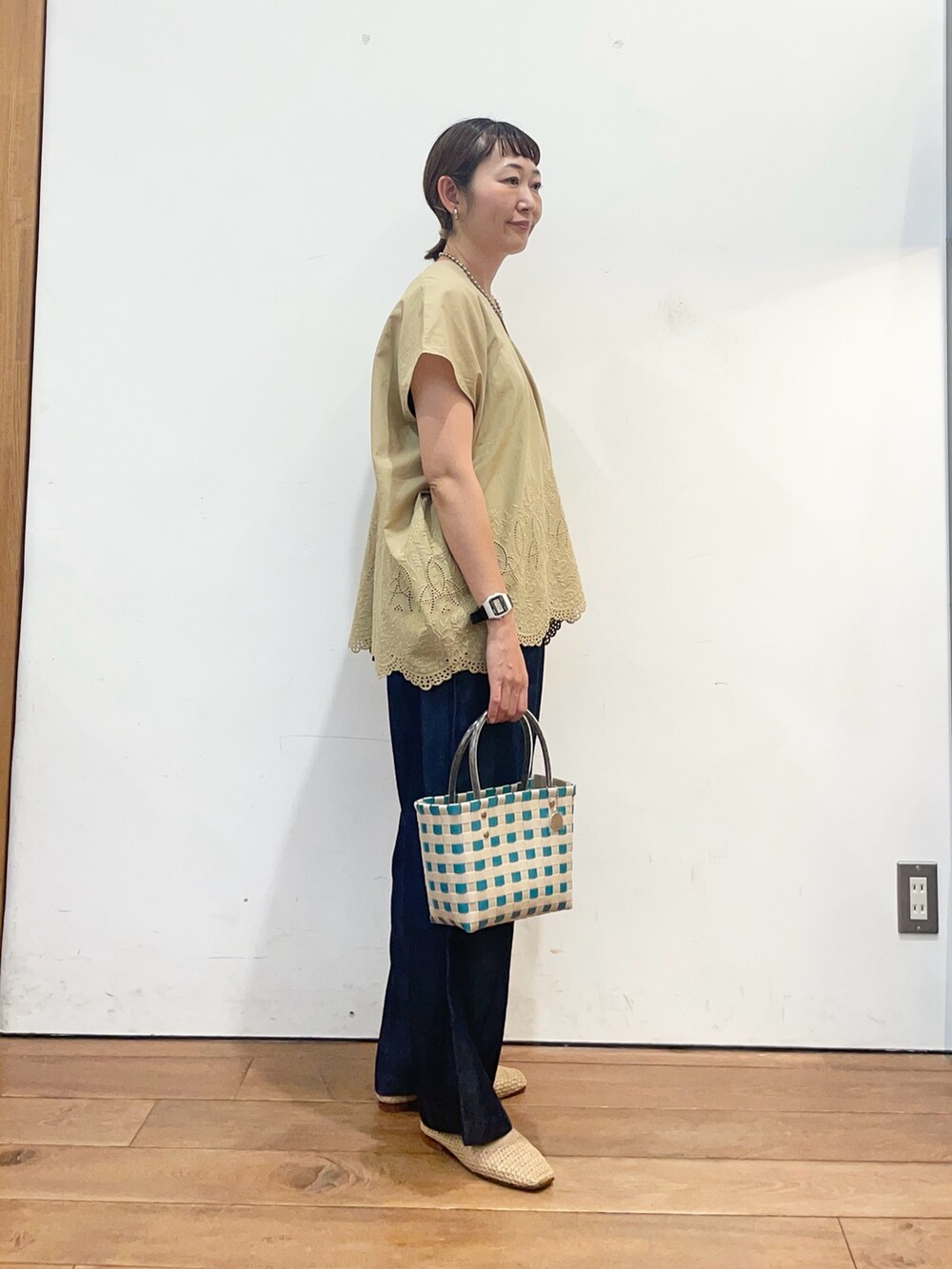 ベージュ系のシャツ/ブラウス、ベージュ系のバレエシューズ、グリーン系のショルダーバッグを着用したレディースの夏コーディネートの4枚目の写真