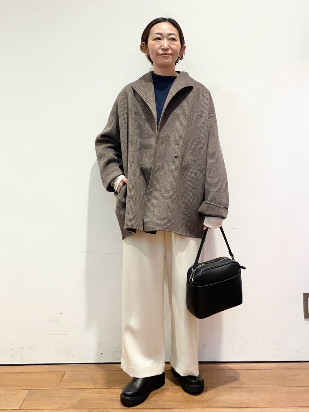 ブルー系のニット/セーター、その他のその他アウター、ブラック系のブーツを着用したレディースの秋コーディネートの2枚目の写真