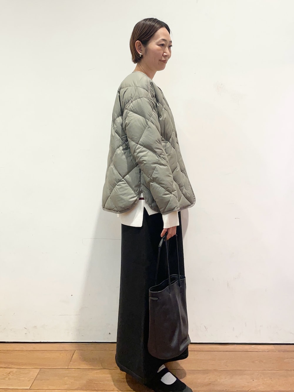 ブラック系のショルダーバッグ、レッド系のニット/セーター、グリーン系のその他アウターを着用したレディースの秋コーディネートの3枚目の写真