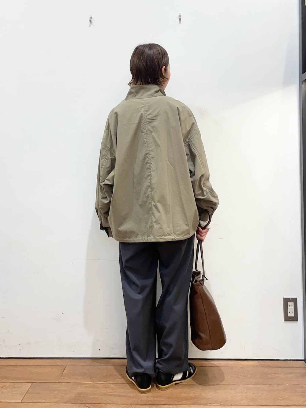 グリーン系のブルゾン、ホワイト系のTシャツ/カットソー、グレー系のその他パンツを着用したレディースの春コーディネートの4枚目の写真