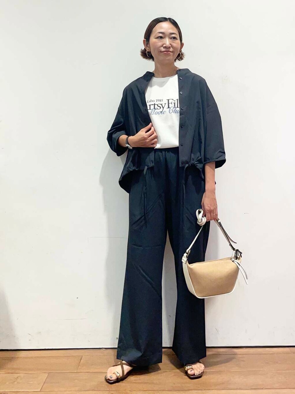 ホワイト系のショルダーバッグ、グレー系のシャツ/ブラウス、グレー系のその他パンツを着用したレディースの夏コーディネートの3枚目の写真