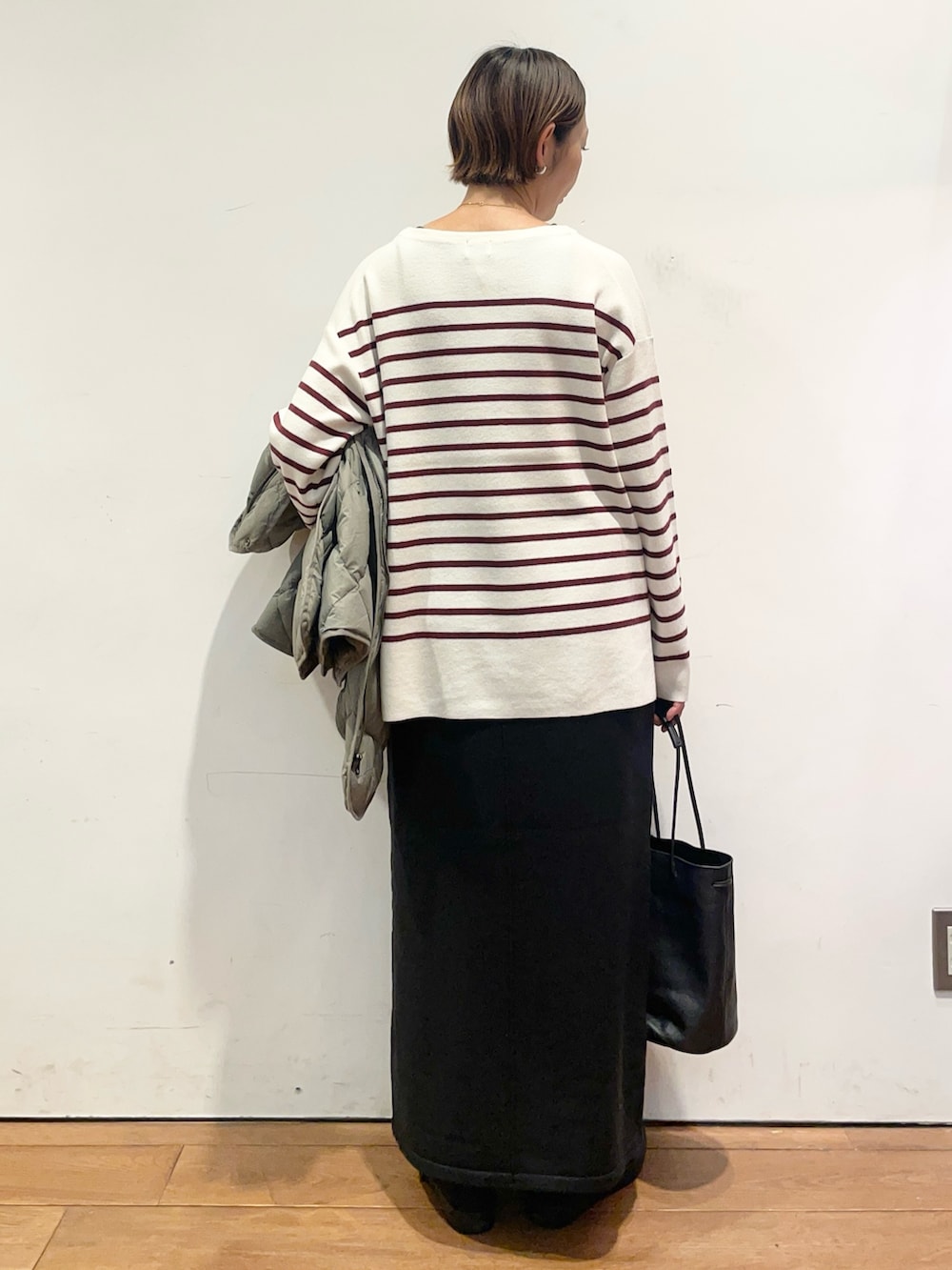 ブラック系のショルダーバッグ、レッド系のニット/セーター、グリーン系のその他アウターを着用したレディースの秋コーディネートの7枚目の写真