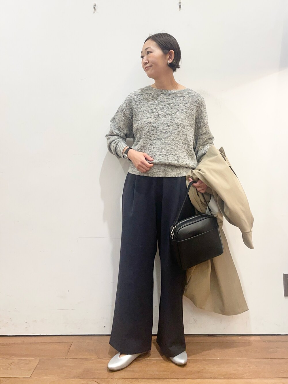 ベージュ系のその他アウター、ブラック系のニット/セーター、シルバー系のパンプスを着用したレディースの春コーディネートの6枚目の写真