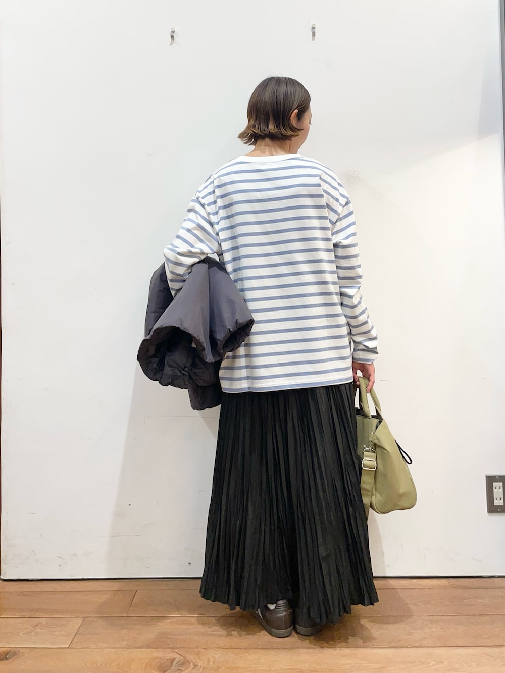 グレー系のブルゾン、ブラック系のスカート、ブルー系のTシャツ/カットソーを着用したレディースの冬コーディネートの7枚目の写真