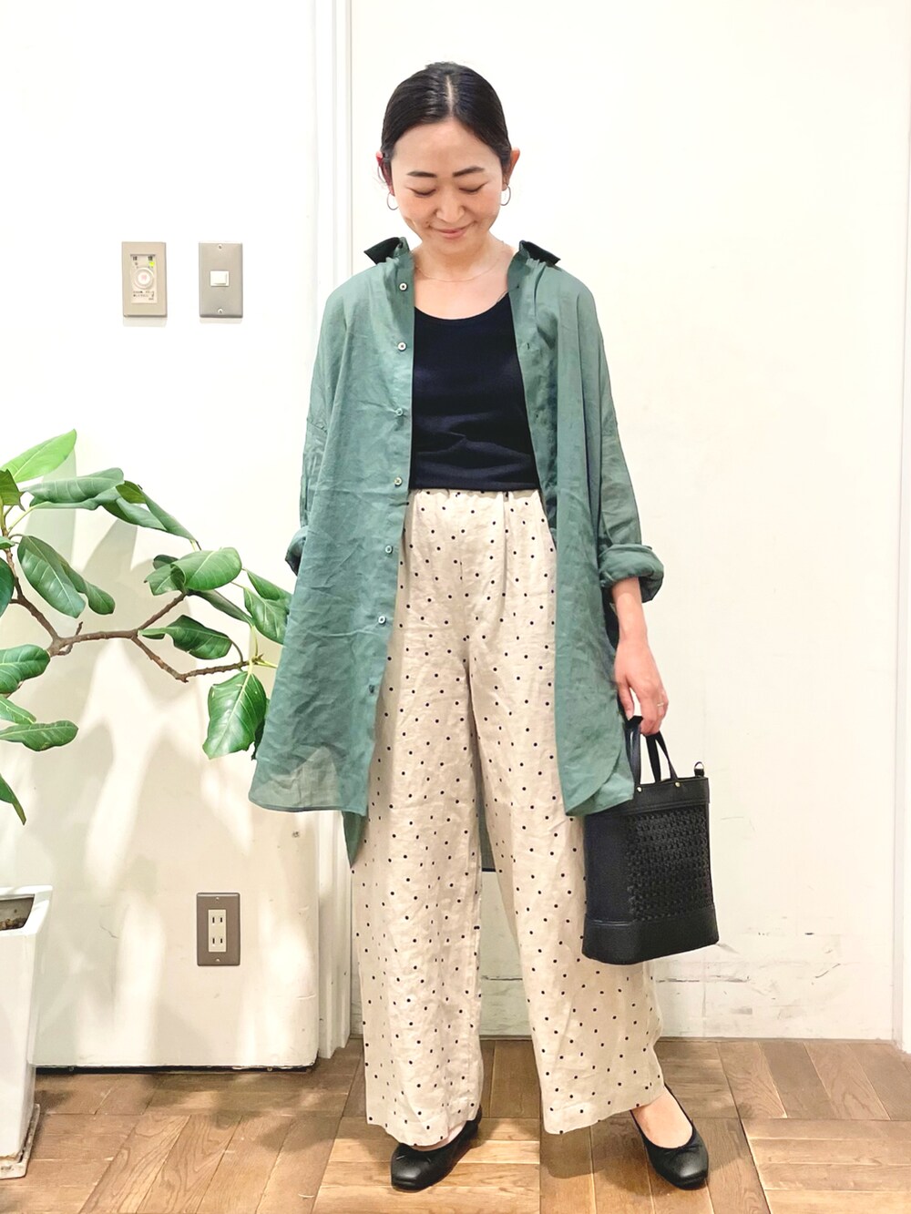 ブラック系のタンクトップ、グリーン系のシャツ/ブラウス、ベージュ系のその他パンツを着用したレディースの春コーディネートの3枚目の写真