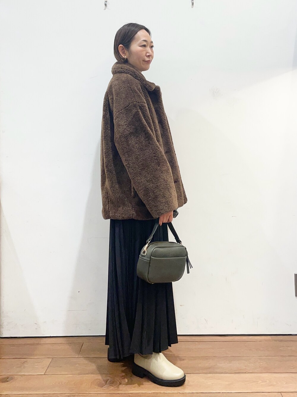 ブラウン系のその他アウター、グレー系のニット/セーター、グリーン系のショルダーバッグを着用したレディースの冬コーディネートの3枚目の写真