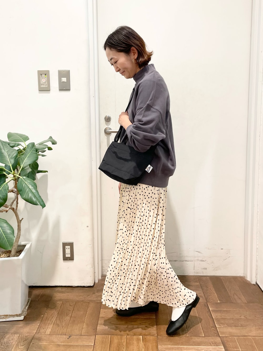 ホワイト系のスカート、パープル系のスウェット、ブラック系のバレエシューズを着用したレディースの冬コーディネートの3枚目の写真