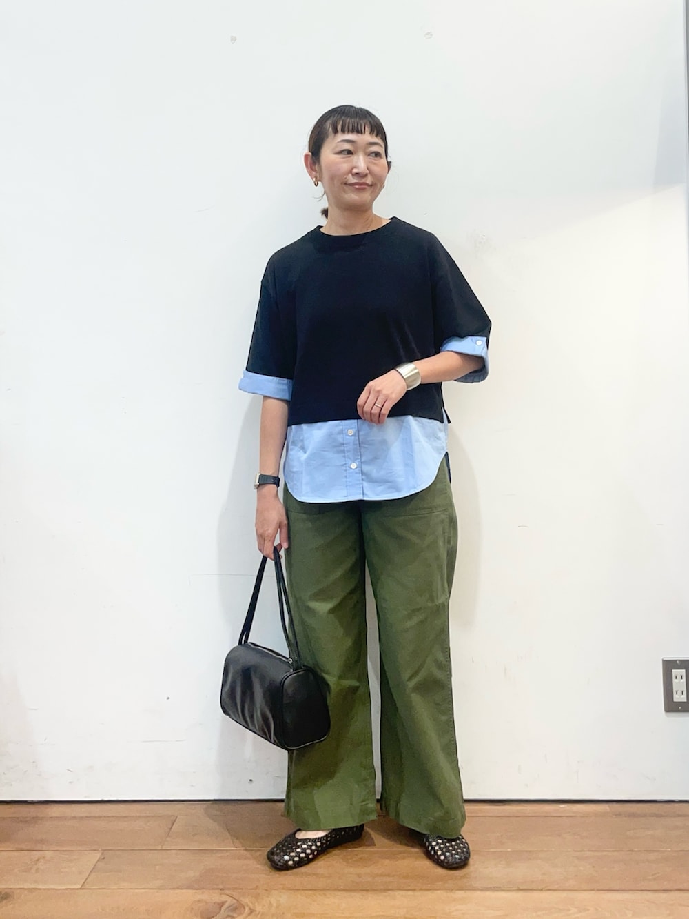 ブラック系のニット/セーター、グリーン系のその他パンツ、ブラック系のハンドバッグを着用したレディースの夏コーディネートの2枚目の写真