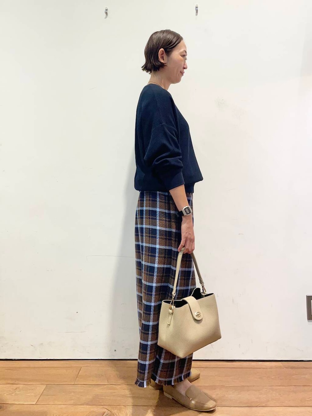 ベージュ系のローファー、ブルー系のTシャツ/カットソー、ベージュ系のショルダーバッグを着用したレディースの秋コーディネートの4枚目の写真