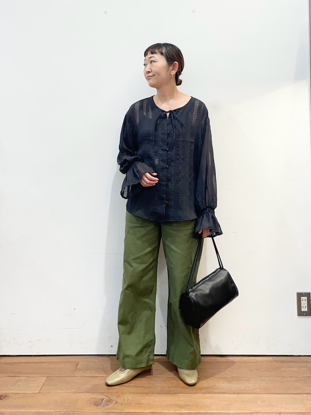 ブラック系のシャツ/ブラウス、グリーン系のその他パンツ、ブラック系のハンドバッグを着用したレディースの秋コーディネートの3枚目の写真