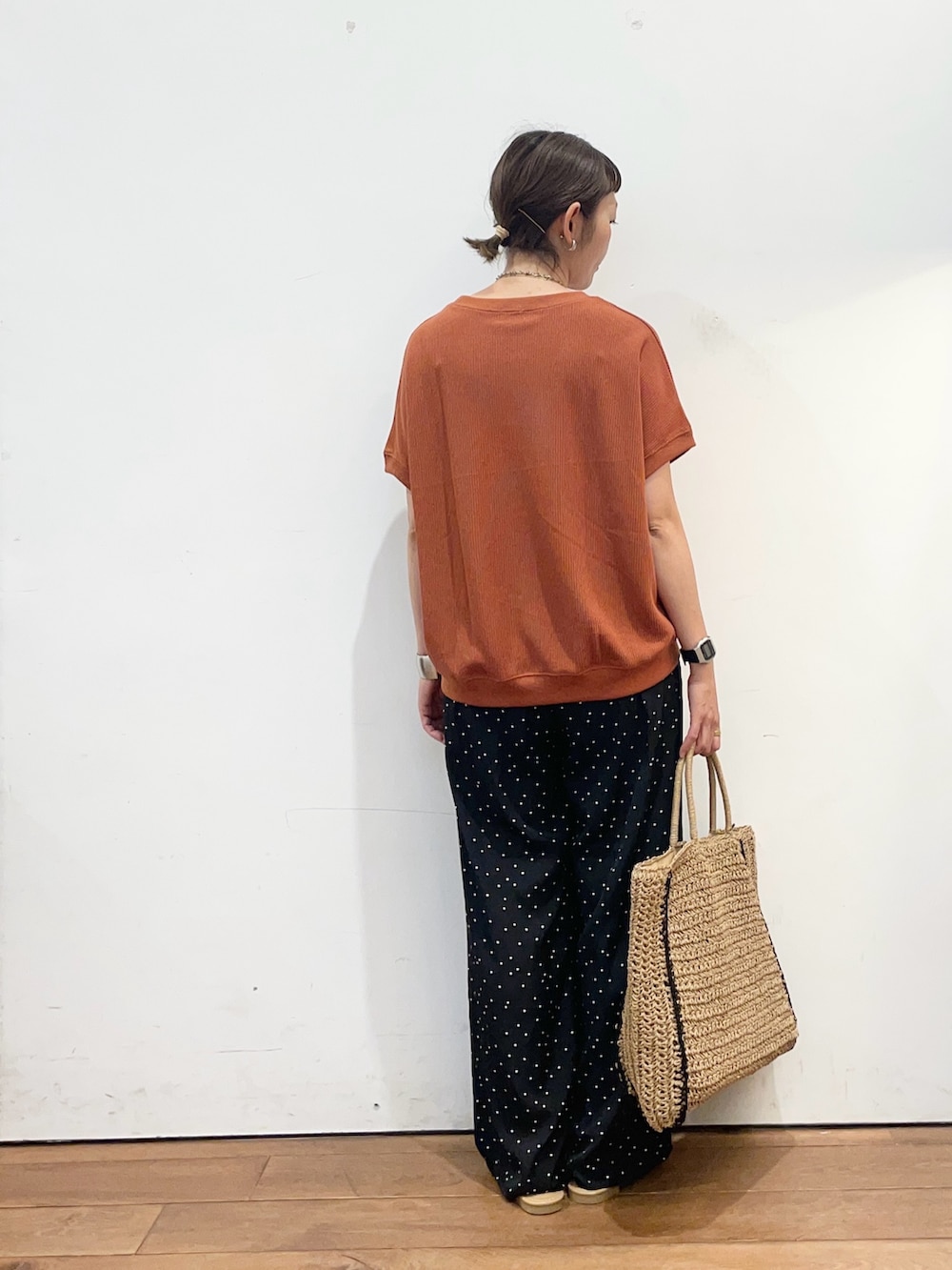 オレンジ系のTシャツ/カットソー、ブラック系のその他パンツ、ベージュ系のトートバッグを着用したレディースの夏コーディネートの4枚目の写真