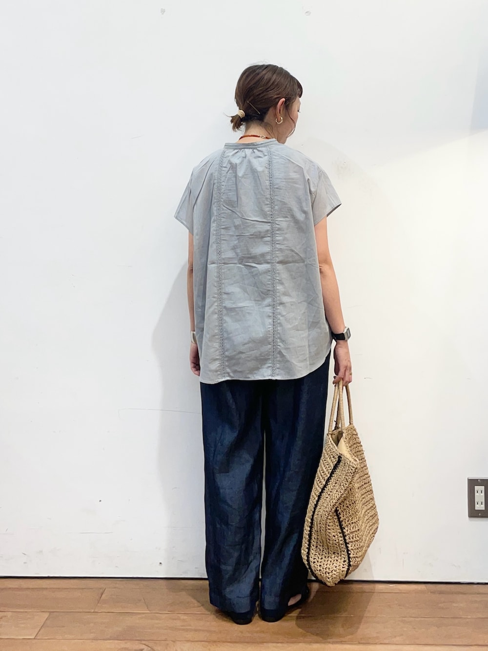 グレー系のシャツ/ブラウス、ブルー系のデニムパンツ、ベージュ系のトートバッグを着用したレディースの夏コーディネートの5枚目の写真