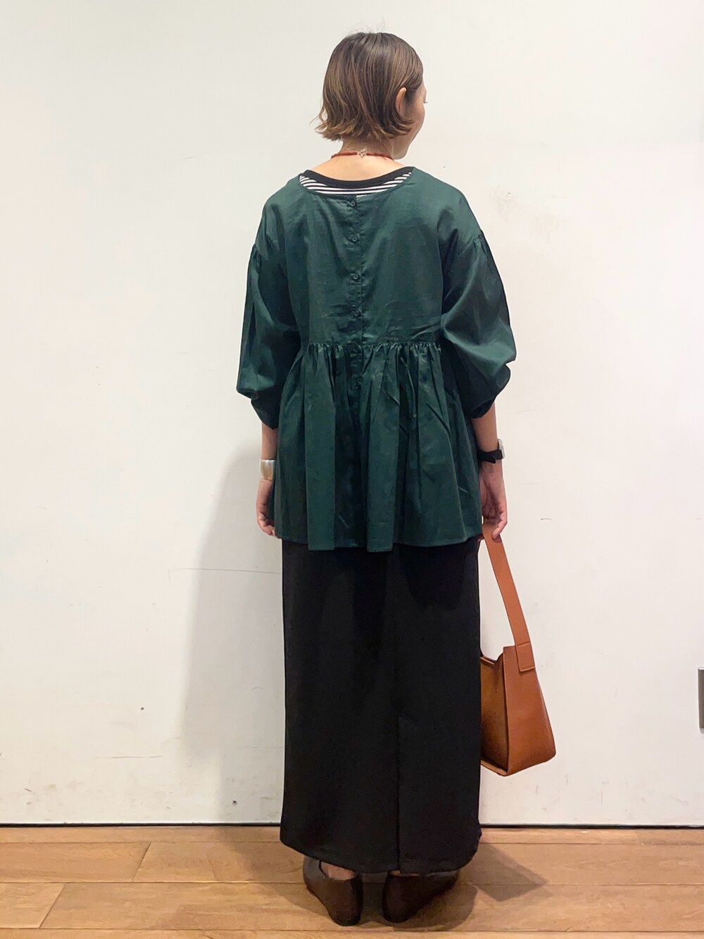 ブラウン系のパンプス、ブラウン系のハンドバッグ、グリーン系のシャツ/ブラウスを着用したレディースの秋コーディネートの5枚目の写真