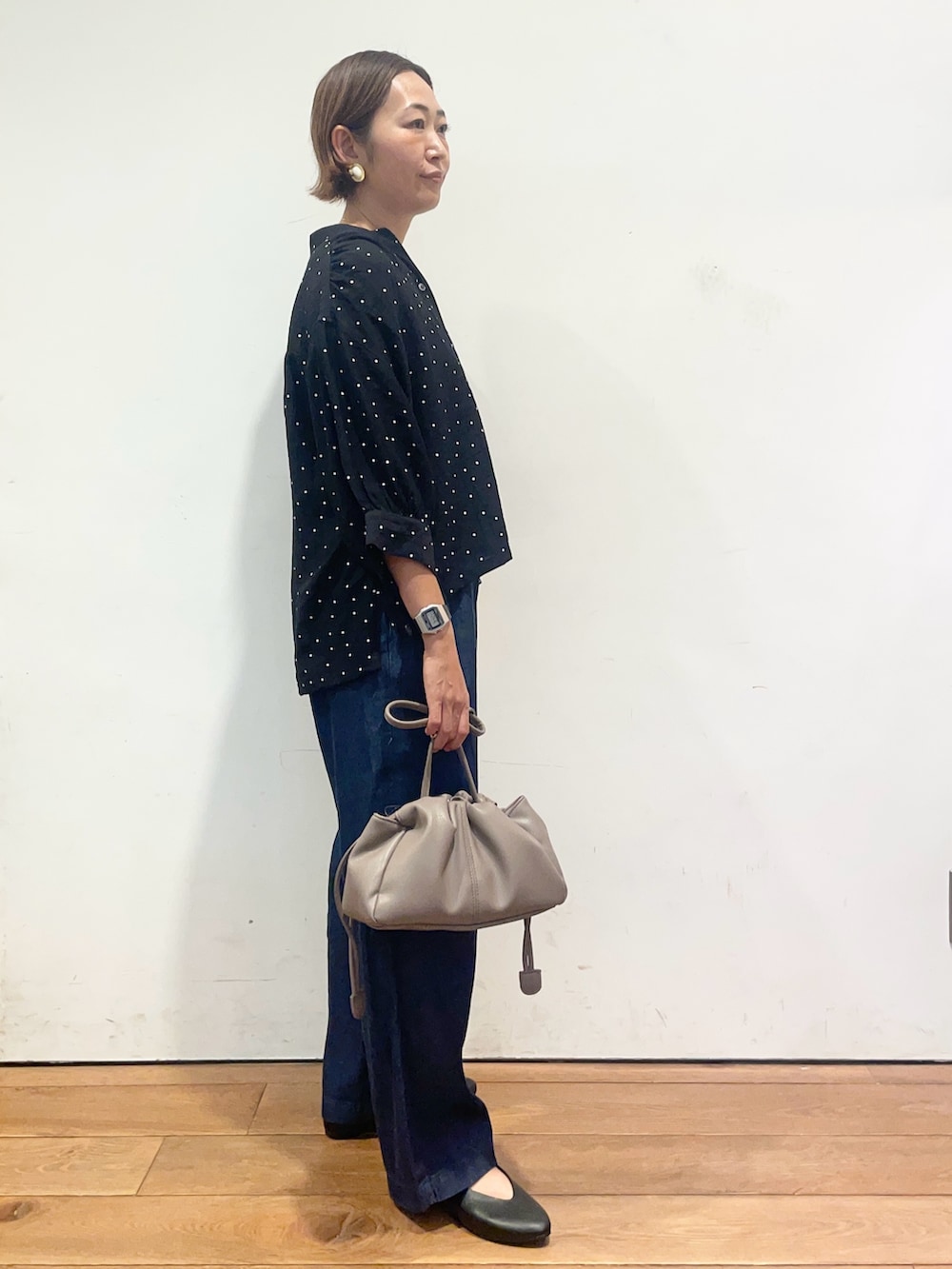 ブラック系のシャツ/ブラウス、ブルー系のデニムパンツ、ベージュ系のショルダーバッグを着用したレディースの夏コーディネートの4枚目の写真