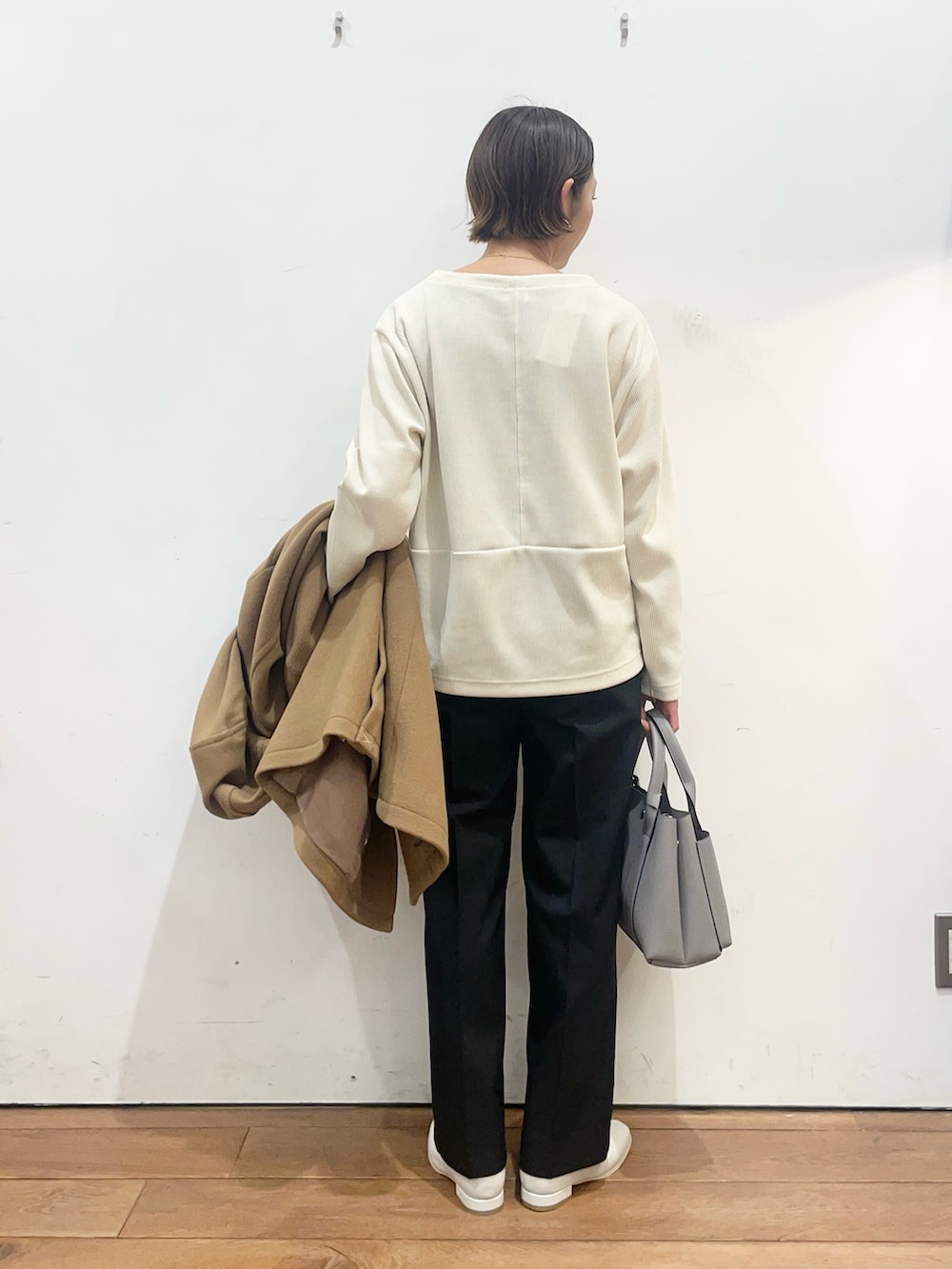 グレー系のトートバッグ、ホワイト系のブーツ、イエロー系のその他アウターを着用したレディースの冬コーディネートの7枚目の写真