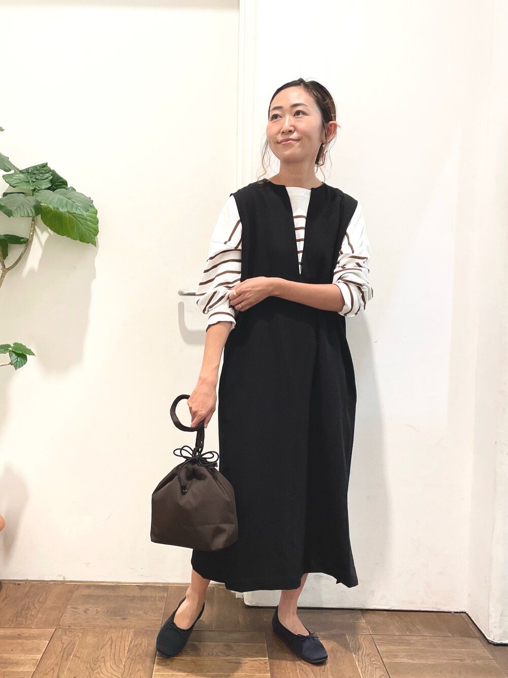 ブラック系のワンピース、ブラウン系のTシャツ/カットソー、ブラウン系のショルダーバッグを着用したレディースの秋コーディネートの4枚目の写真
