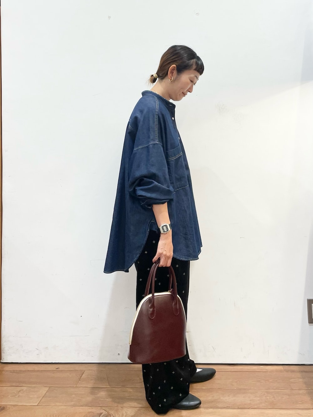 ブルー系のシャツ/ブラウス、レッド系のハンドバッグ、ブラック系のパンプスを着用したレディースの秋コーディネートの4枚目の写真