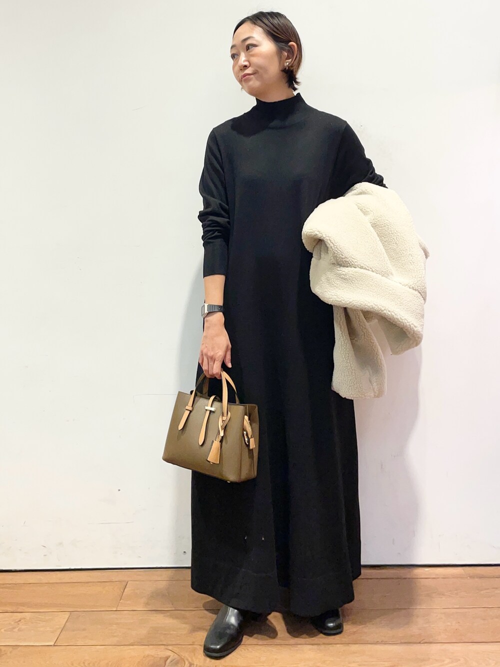 ホワイト系のその他アウター、ブラウン系のハンドバッグ、ブラック系のワンピースを着用したレディースの冬コーディネートの6枚目の写真