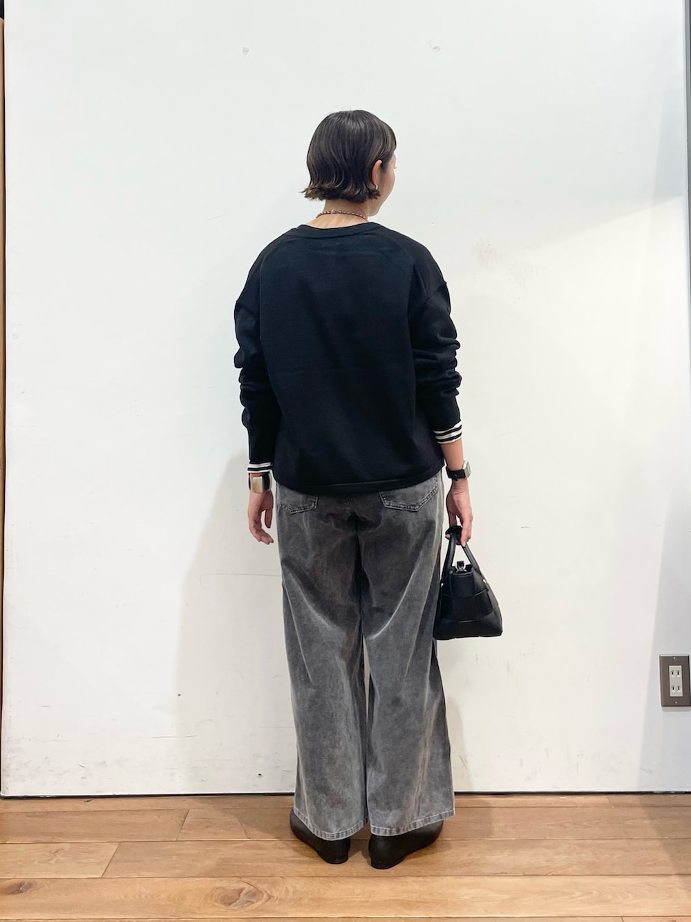 ブラック系のカーディガン/ボレロ、ホワイト系のTシャツ/カットソー、ブラック系のスリッポンを着用したレディースの秋コーディネートの5枚目の写真
