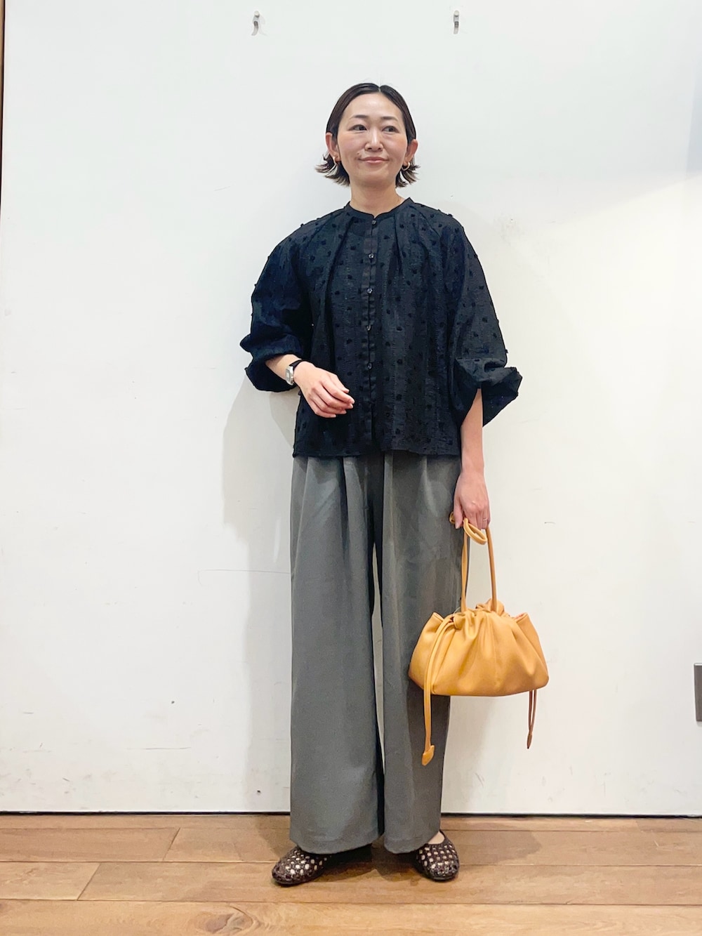 ブラック系のシャツ/ブラウス、ブラウン系のサンダル、グレー系のその他パンツを着用したレディースの春コーディネートの2枚目の写真