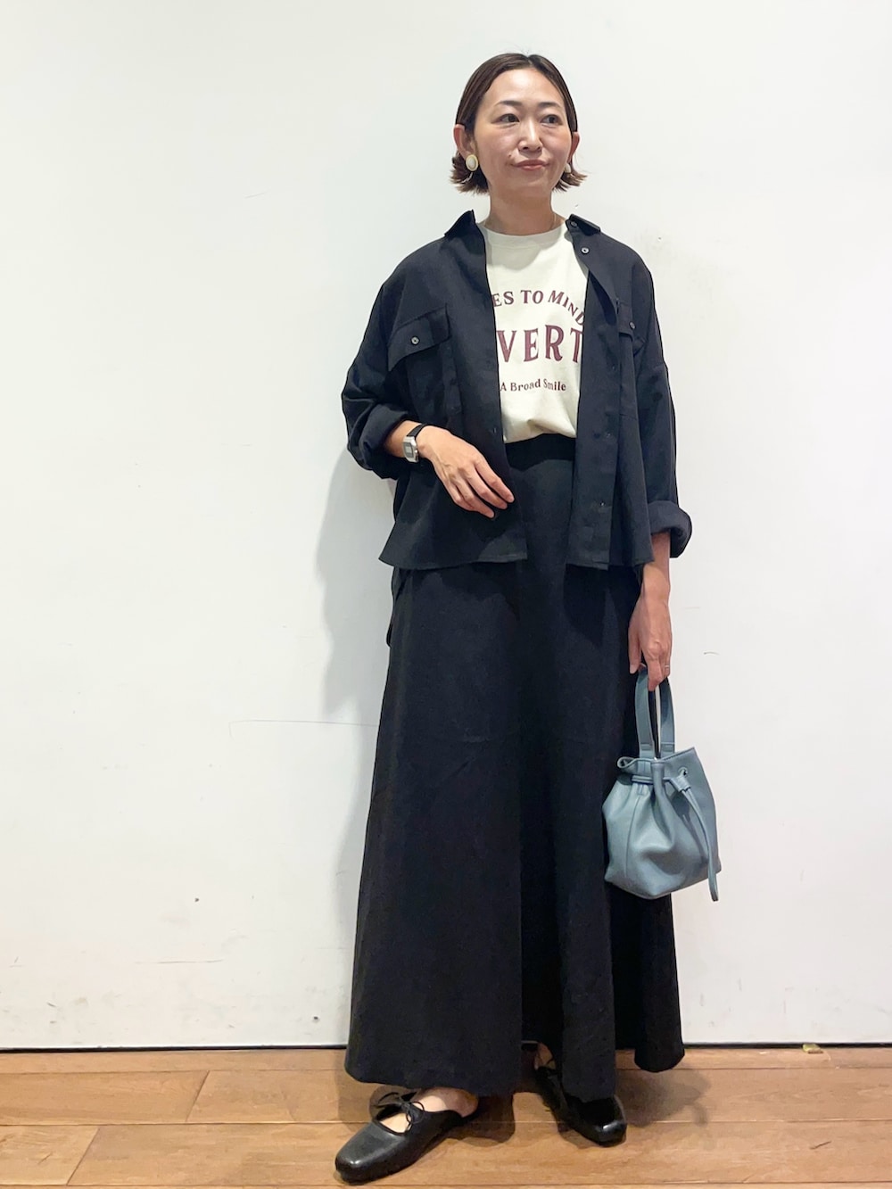 ベージュ系のTシャツ/カットソー、ブラック系のシャツ/ブラウス、ブラック系のスカートを着用したレディースの秋コーディネートの2枚目の写真