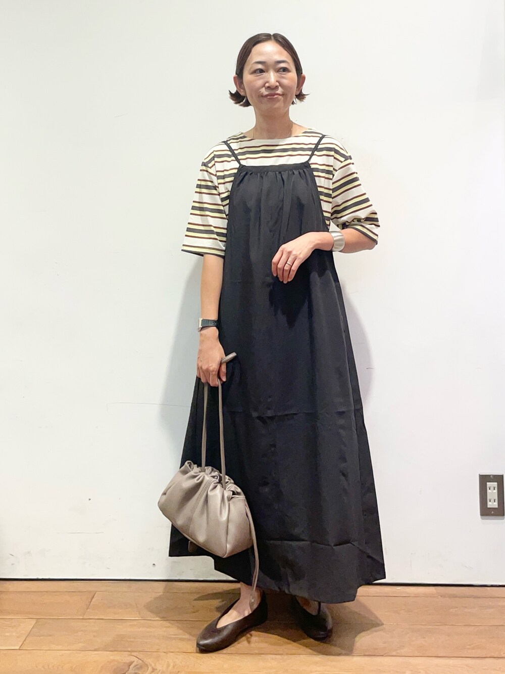 ホワイト系のTシャツ/カットソー、ブラック系のワンピース、ベージュ系のショルダーバッグを着用したレディースの夏コーディネートの2枚目の写真