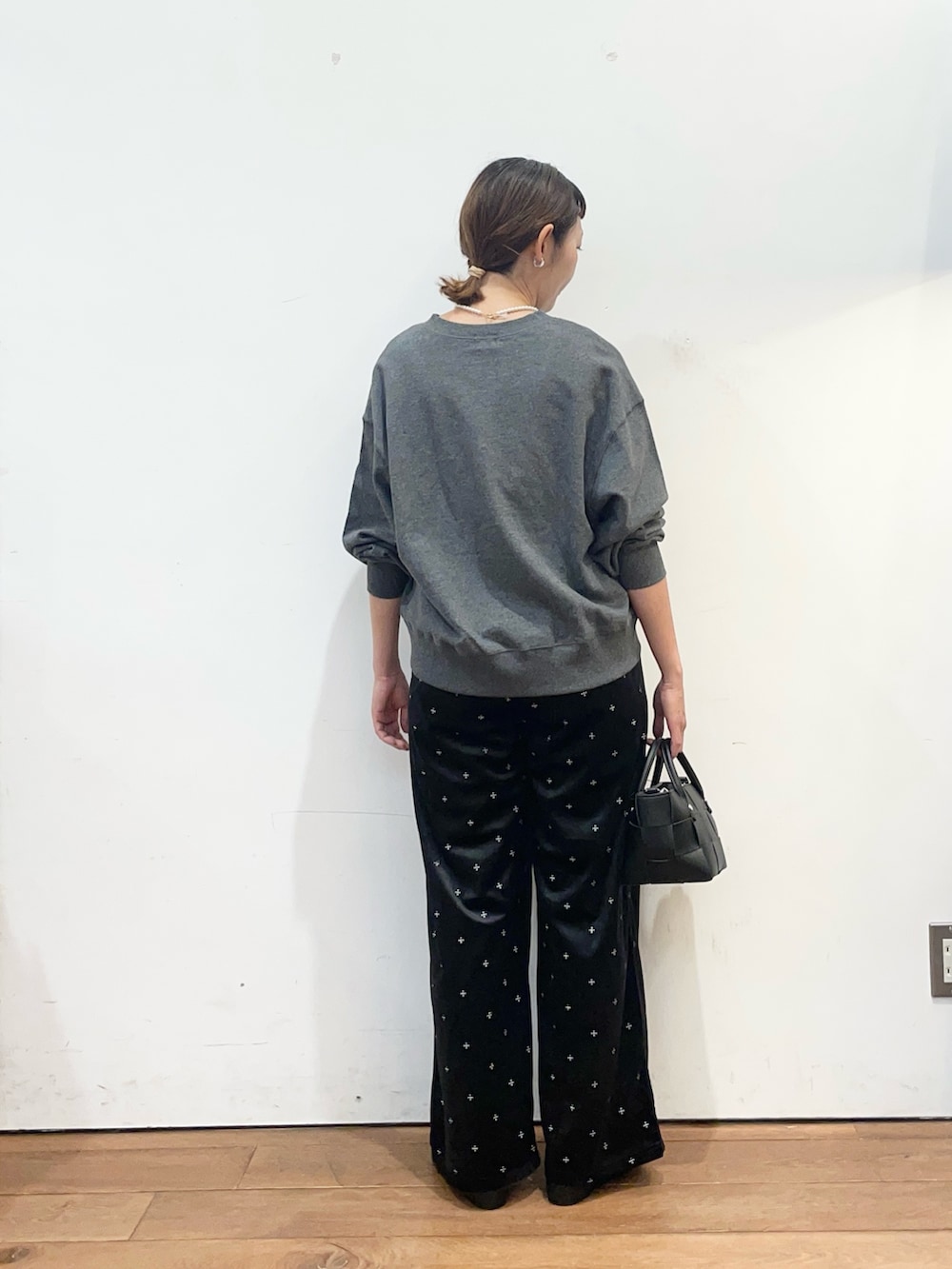 グレー系のカーディガン/ボレロ、ホワイト系のタンクトップ、ブラック系のパンプスを着用したレディースの秋コーディネートの5枚目の写真