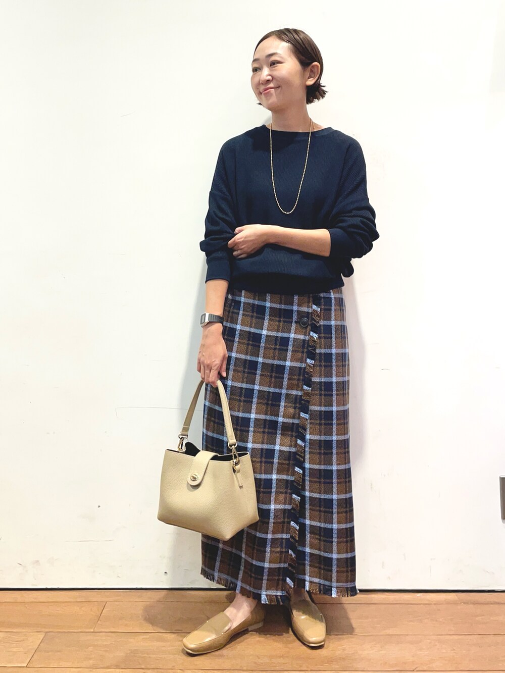 ブルー系のTシャツ/カットソー、ブラウン系のスカート、ベージュ系のローファーを着用したレディースの秋コーディネートの2枚目の写真