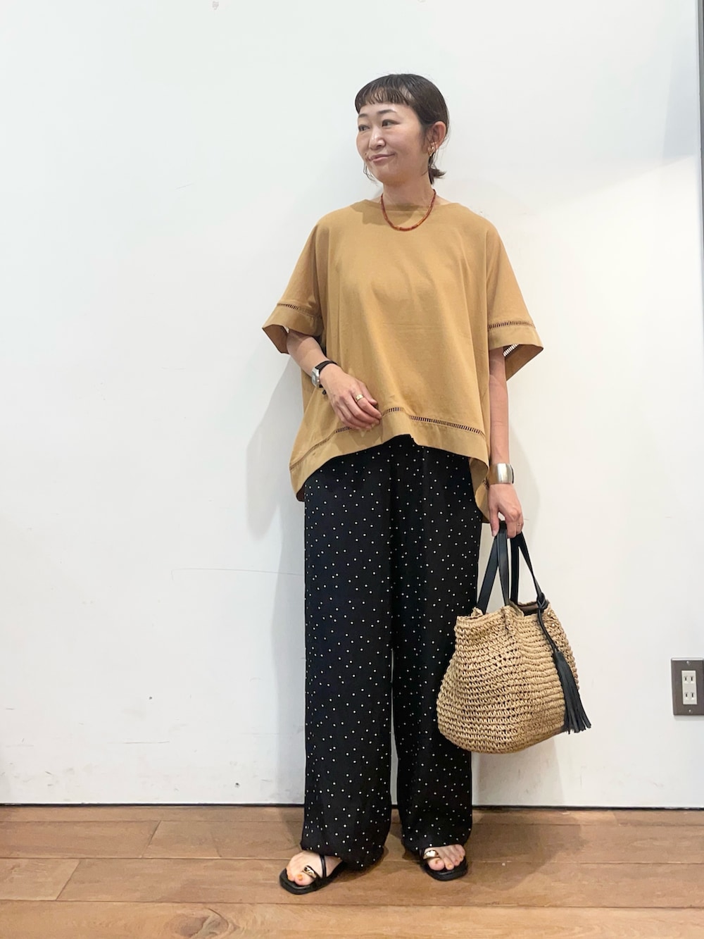 イエロー系のTシャツ/カットソー、ブラック系のその他パンツ、イエロー系のかごバッグを着用したレディースの夏コーディネートの2枚目の写真