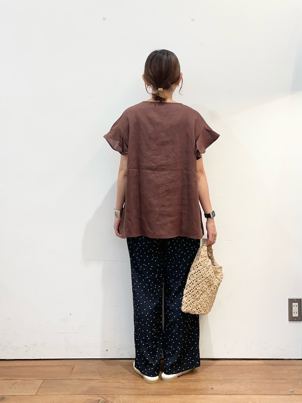 ブラウン系のシャツ/ブラウス、ブルー系のその他パンツ、ベージュ系のハンドバッグを着用したレディースの夏コーディネートの4枚目の写真