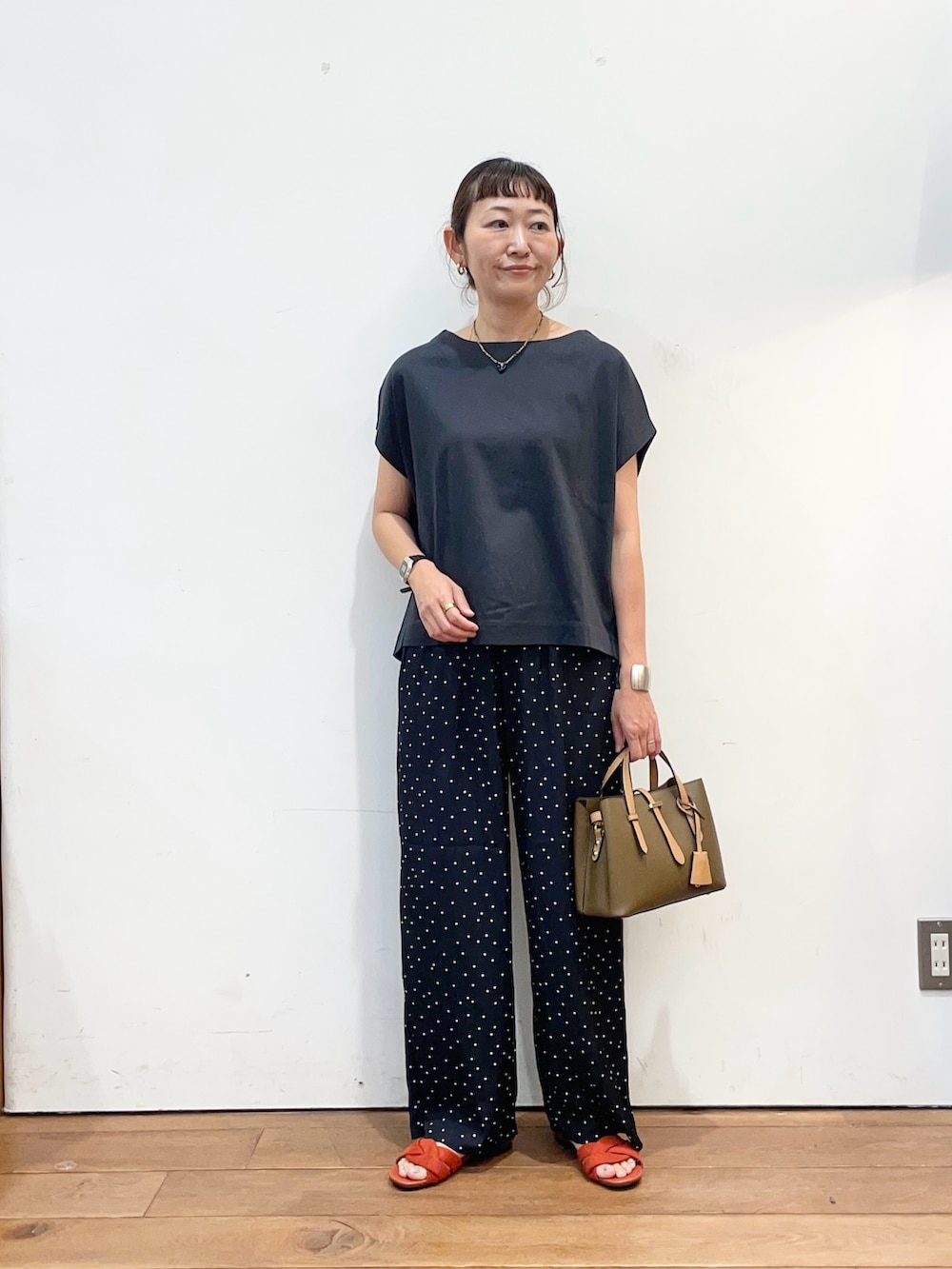 ブラウン系のハンドバッグ、レッド系のサンダル、ブルー系のその他パンツを着用したレディースの夏コーディネートの2枚目の写真