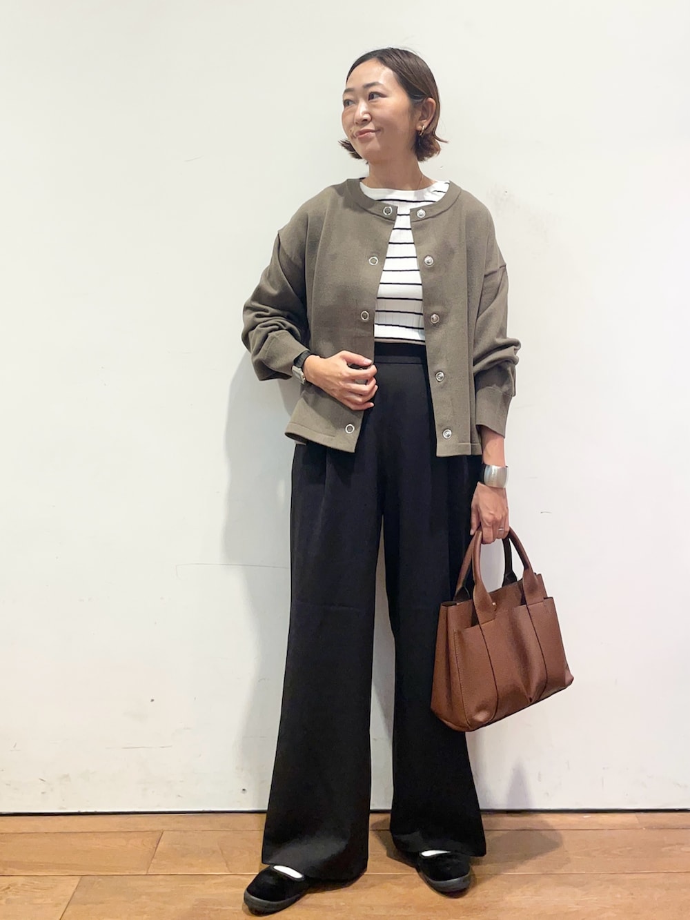 ブラウン系のカーディガン/ボレロ、ブラウン系のトートバッグ、ブラック系のその他パンツを着用したレディースの秋コーディネートの2枚目の写真