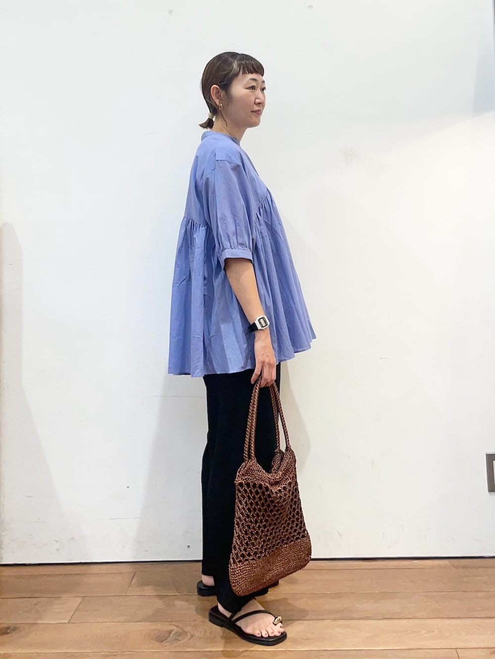 ブルー系のシャツ/ブラウス、ブラック系のその他パンツ、ブラウン系のトートバッグを着用したレディースの夏コーディネートの4枚目の写真