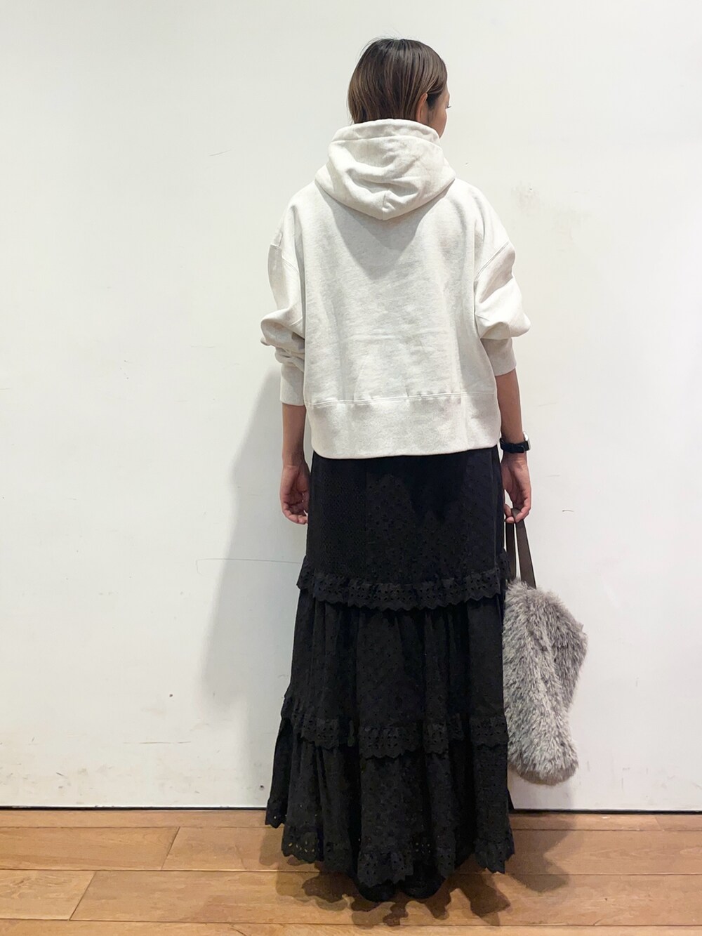 ベージュ系のパーカー、ブラック系のスカート、ブラック系のバレエシューズを着用したレディースの秋コーディネートの5枚目の写真