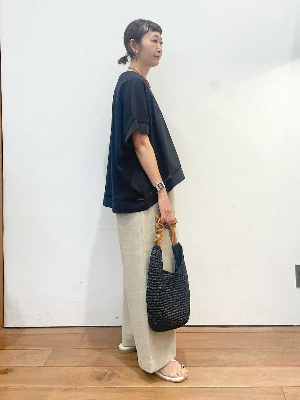 ブラック系のTシャツ/カットソー、ベージュ系のその他パンツ、オレンジ系のかごバッグを着用したレディースの夏コーディネートの3枚目の写真
