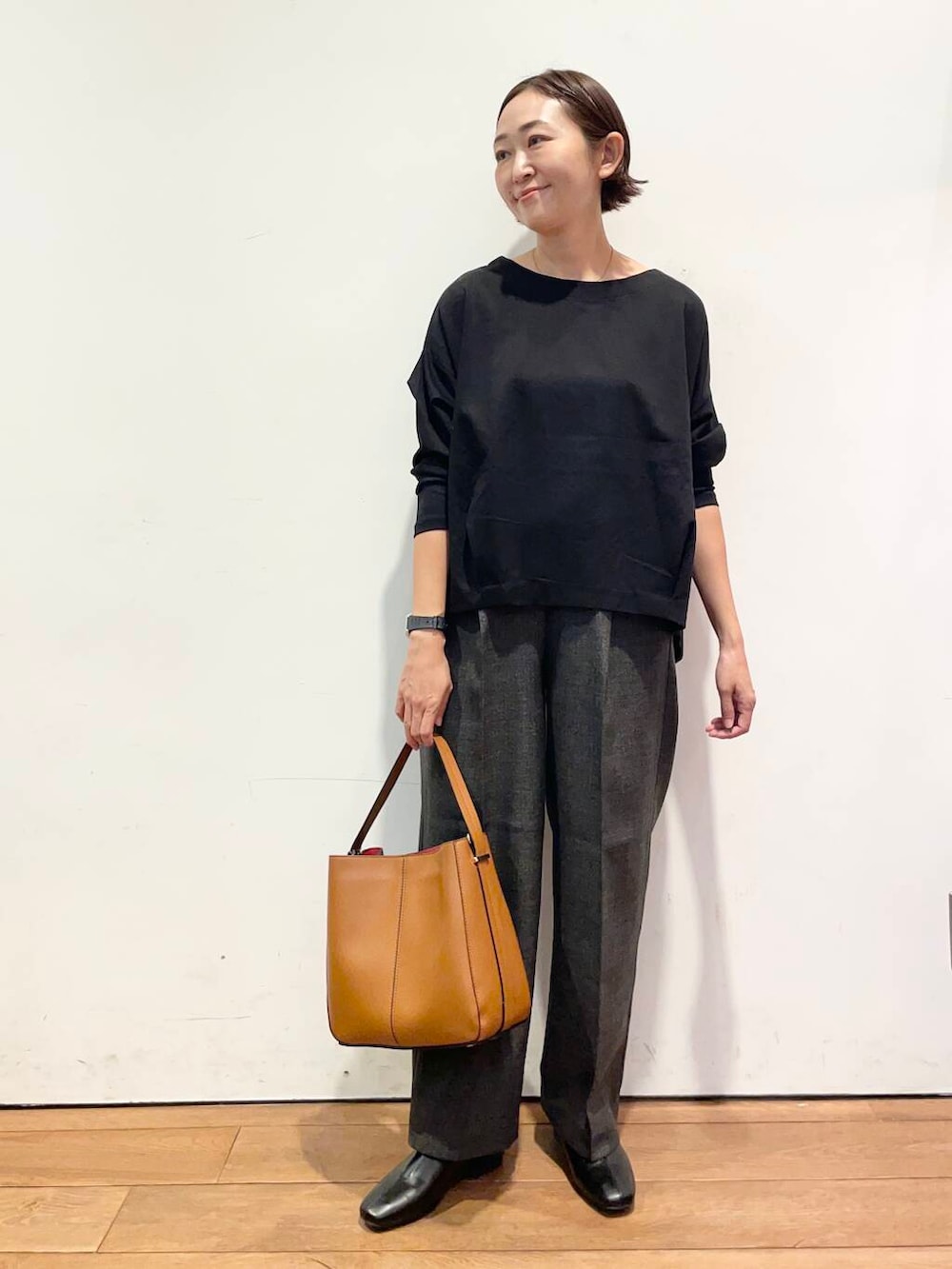 ブラウン系のハンドバッグ、ブラック系のTシャツ/カットソー、グレー系のその他パンツを着用したレディースの秋コーディネートの2枚目の写真