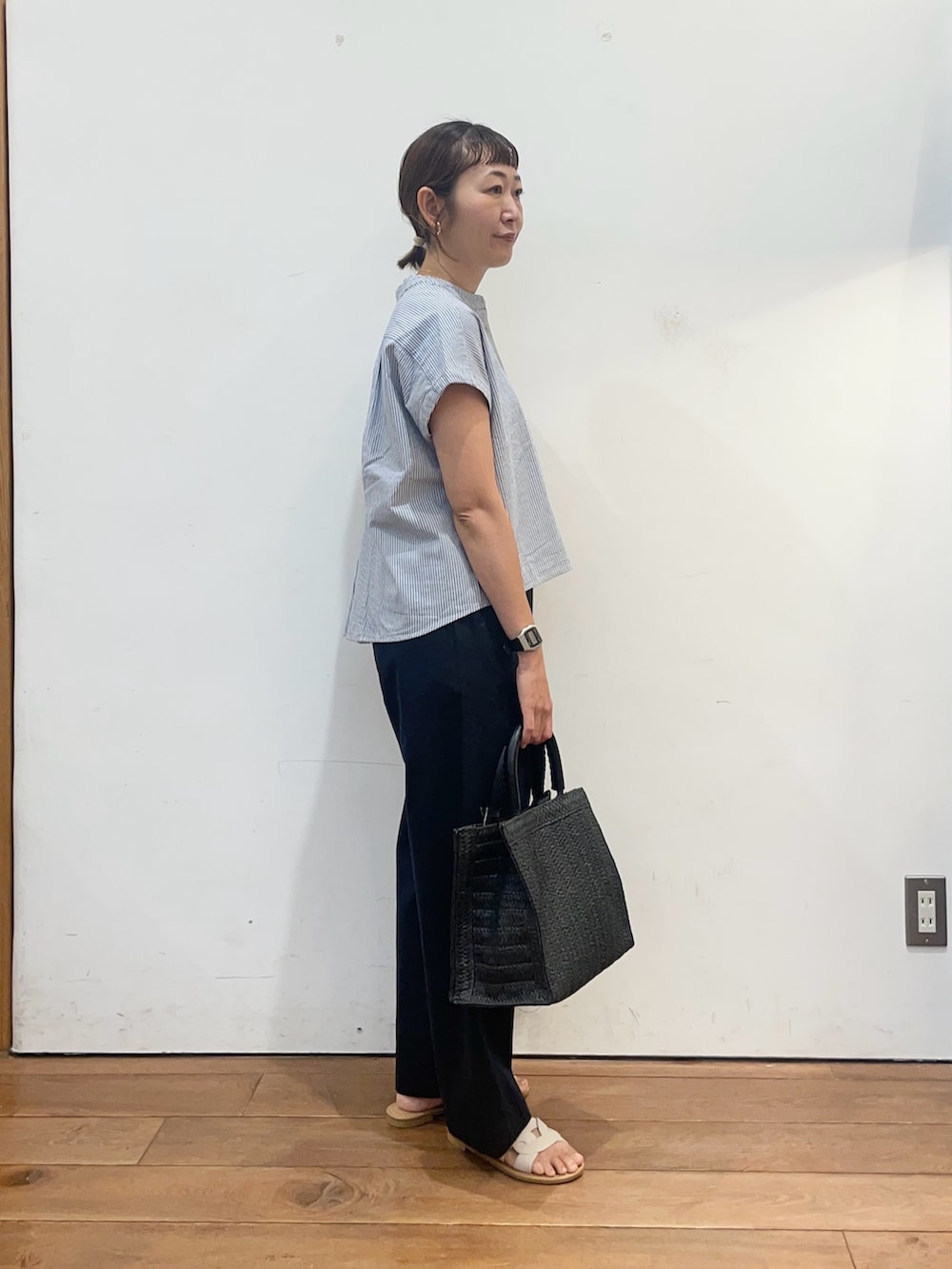 ホワイト系のサンダル、ブラック系のハンドバッグ、ブルー系のその他パンツを着用したレディースの夏コーディネートの3枚目の写真