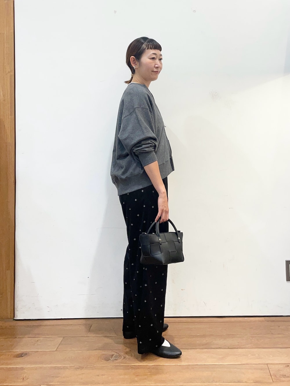 グレー系のカーディガン/ボレロ、ホワイト系のタンクトップ、ブラック系のパンプスを着用したレディースの秋コーディネートの4枚目の写真