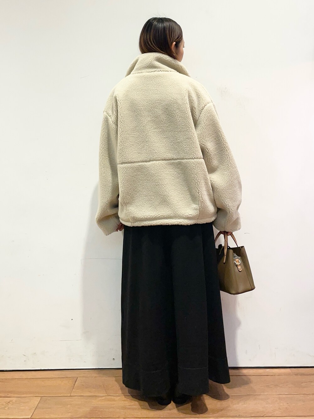 ホワイト系のその他アウター、ブラウン系のハンドバッグ、ブラック系のワンピースを着用したレディースの冬コーディネートの5枚目の写真