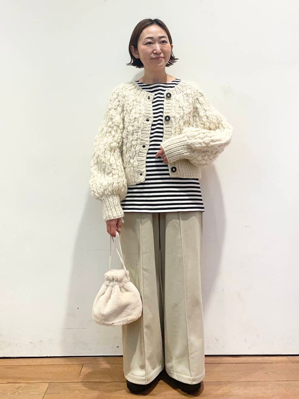 ホワイト系のカーディガン/ボレロ、シルバー系のブーツ、ベージュ系のその他パンツを着用したレディースの冬コーディネートの2枚目の写真