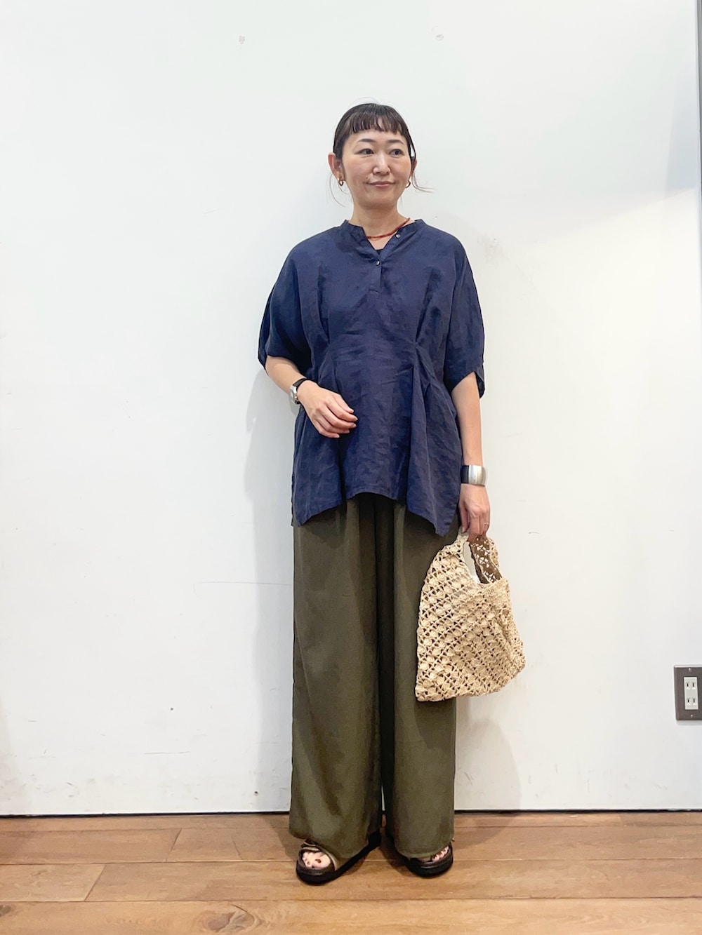 ブルー系のシャツ/ブラウス、グリーン系のその他パンツ、ベージュ系のハンドバッグを着用したレディースの夏コーディネートの2枚目の写真