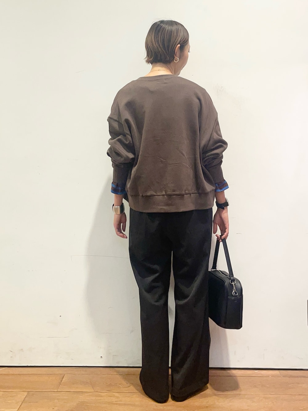ブラウン系のカーディガン/ボレロ、ブラウン系のTシャツ/カットソー、ブラック系のその他パンツを着用したレディースの秋コーディネートの6枚目の写真