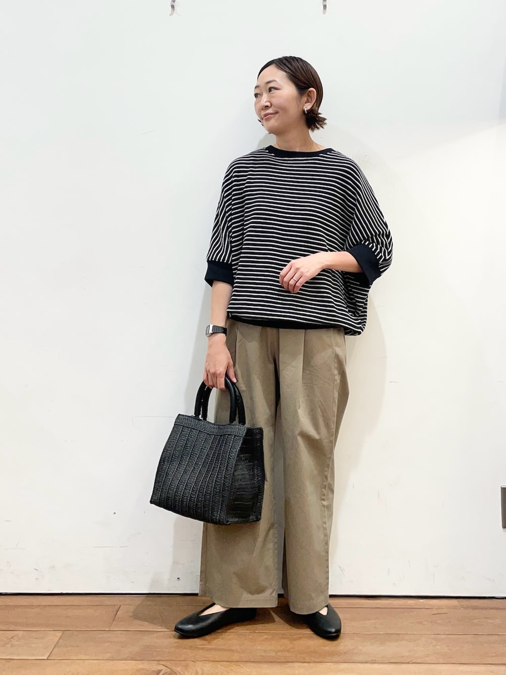 ブラック系のTシャツ/カットソー、ブラック系のパンプス、ブラック系のハンドバッグを着用したレディースの春コーディネートの2枚目の写真