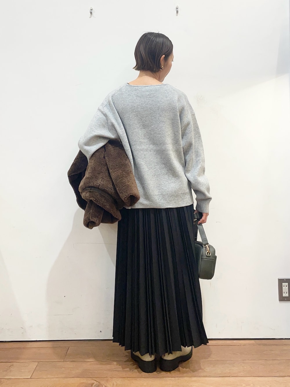 ブラウン系のその他アウター、グレー系のニット/セーター、グリーン系のショルダーバッグを着用したレディースの冬コーディネートの8枚目の写真