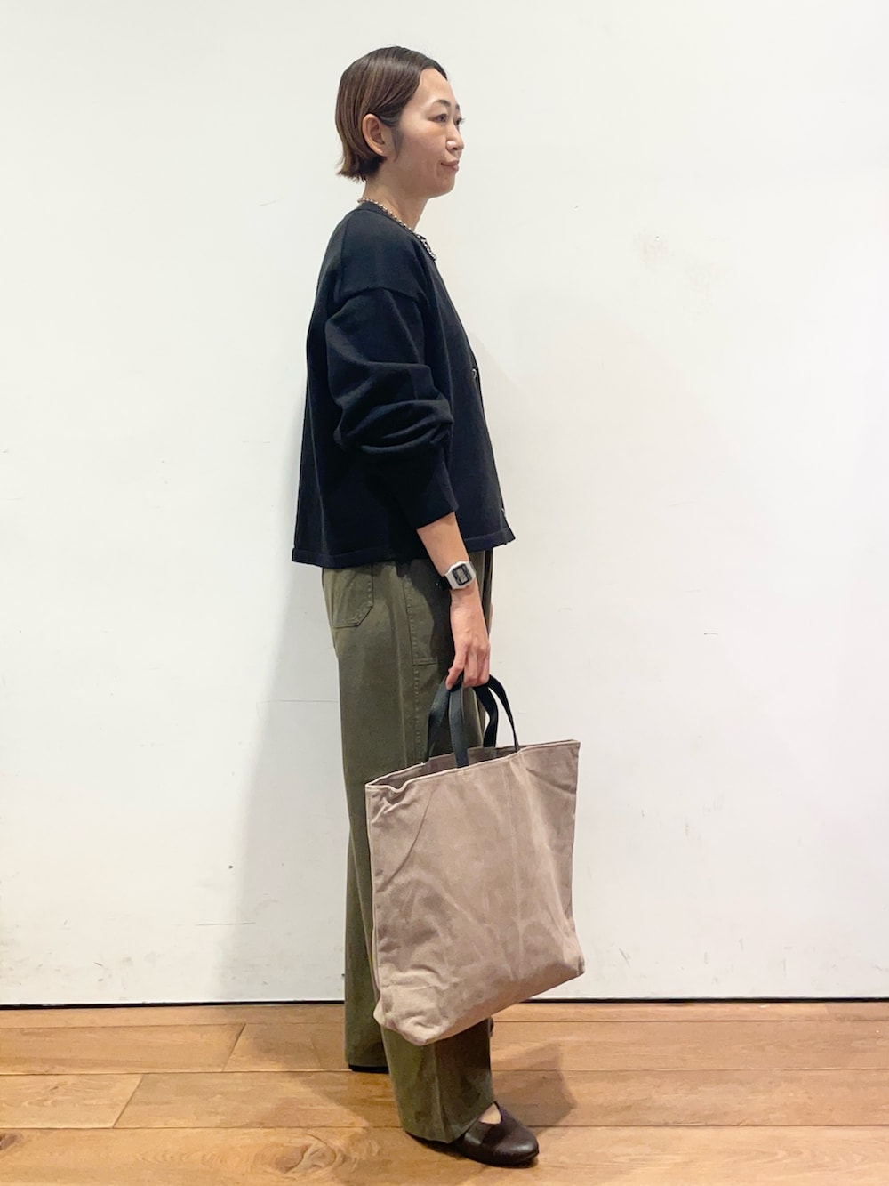 ブラック系のカーディガン/ボレロ、ブラウン系のパンプス、グレー系のバッグを着用したレディースの秋コーディネートの4枚目の写真