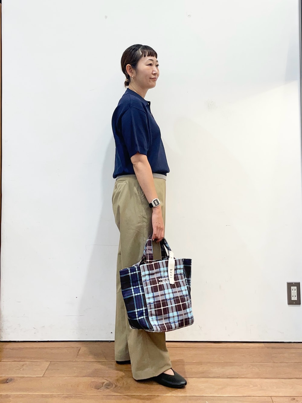 ブルー系のポロシャツ、ベージュ系のその他パンツ、ブラウン系のトートバッグを着用したレディースの秋コーディネートの3枚目の写真