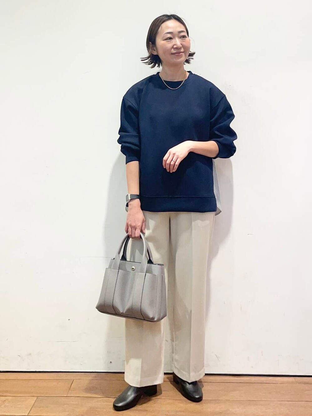 ブラック系のブーツ、ホワイト系のその他パンツ、グレー系のトートバッグを着用したレディースの冬コーディネートの3枚目の写真