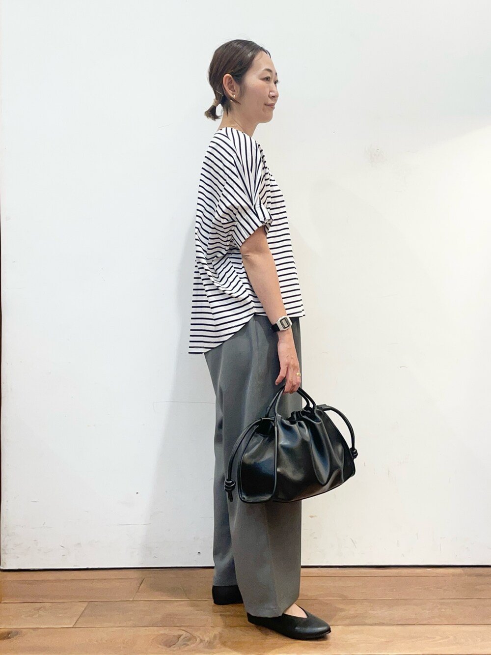 ホワイト系のTシャツ/カットソー、ブラック系のパンプス、ブラック系のトートバッグを着用したレディースの春コーディネートの4枚目の写真