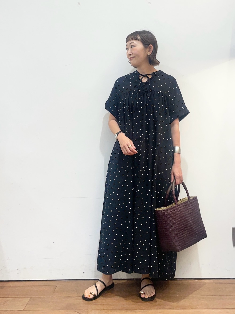 ブラック系のワンピース、ブラック系のサンダル、ブラウン系のトートバッグを着用したレディースの夏コーディネートの2枚目の写真